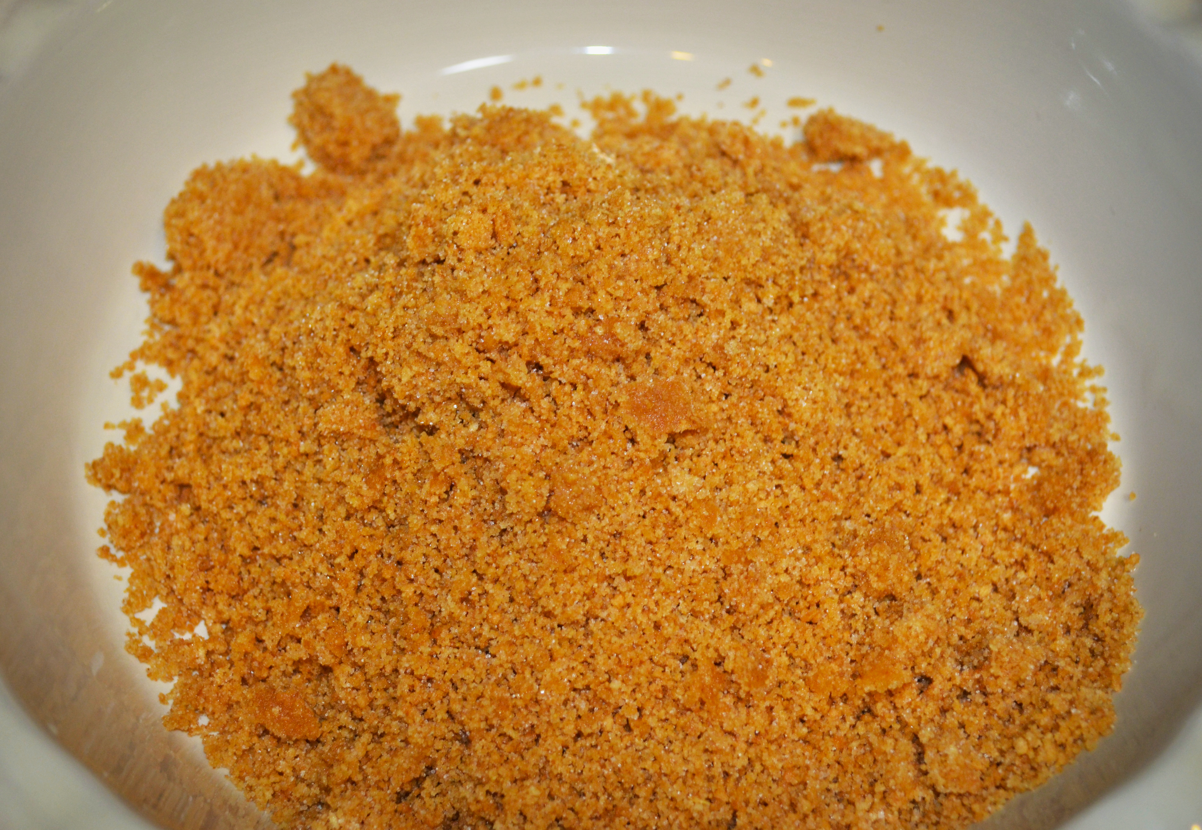 Step five, pour the crumbs into your chosen baking dish.  Ideally one would use a springform pan, but I have never owned one, so a pie plate did the trick for us.